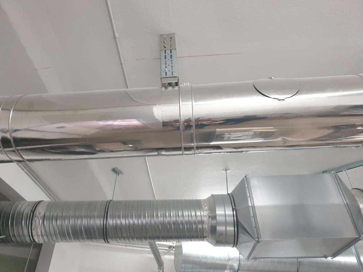 Installation von isolierten Wickelfalzrohren und rechteckigen Lüftungskanälen für eine Abluftanlage.