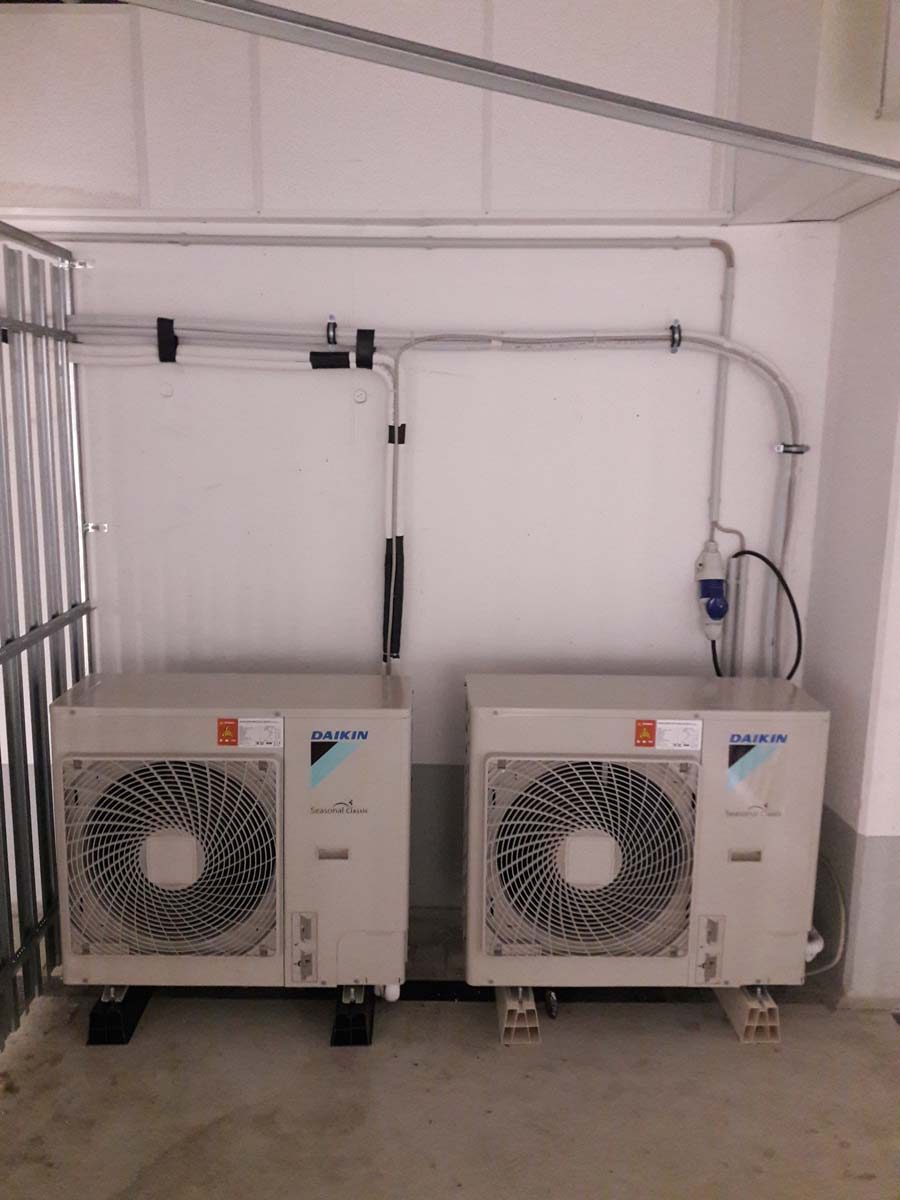 Installation von zwei Daikin Seasonal Classic Klimaanlagen-Außengeräten in einem Technikraum.